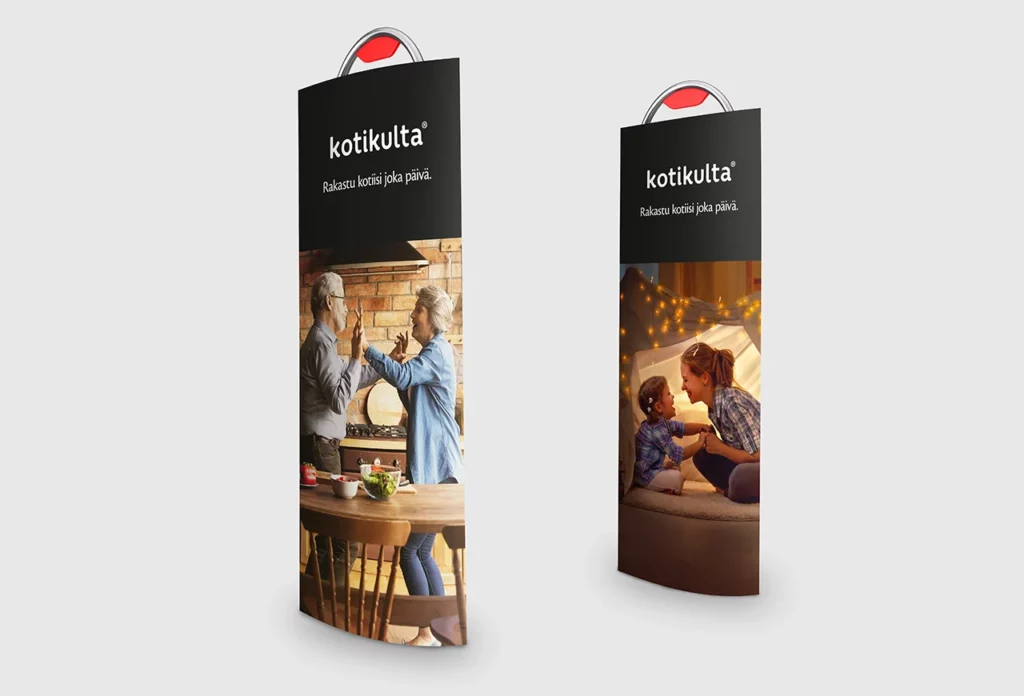 Kaksi Kotikulta-mainostelinettä, joissa teksti “Rakastu kotiisi joka päivä.” Vasemman puoleisessa kuvassa varttunut pariskunta tanssii hymyillen keittiössä, oikealla äiti ja lapsi leikkivät iltavalaistussa majassa.