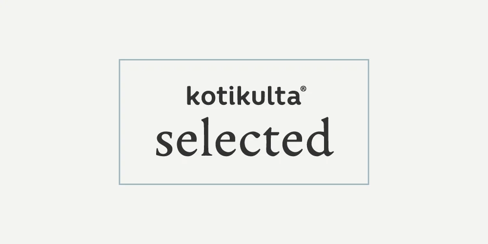 Kotikulta selected -logo mustalla tekstillä läpinäkyvässä suorakulmaisessa laatikossa vaaleanharmaalla taustalla. Laatikon reunalla kulkee harmaa kehys, joka rajaa laatikon visuaalisesti. Kotikulta on sijoitettu laatikossa keskitetysti selected-sanan päälle.